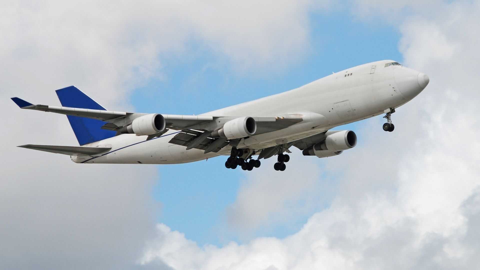 Boeing 777 freighter aircraft in flight during a global air cargo charter mission with landing gear extended.